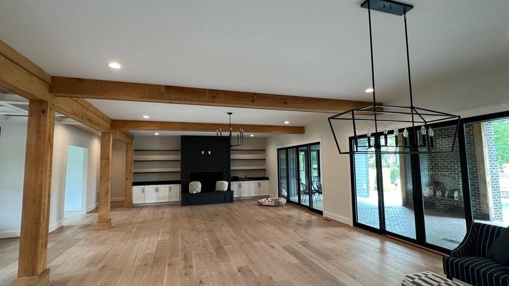 Home addition with timber beams and fireplace